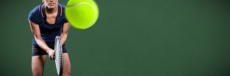 Tennis player playing tennis with a racket  against green backgroundの写真素材