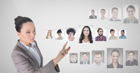 Digital composite of Woman touching portrait profiles of different peopleの写真素材