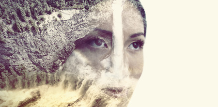 Waterfall and forest around a circle against close-up of thoughtful womanの写真素材