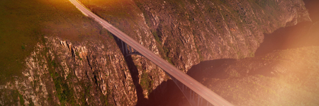Aerial view of bridge over mountain on a sunny dayの写真素材