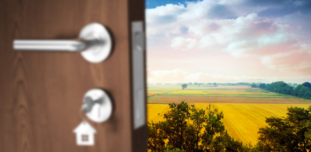 Digitally generated image of brown door with key against landscape of multiple grass fieldの写真素材