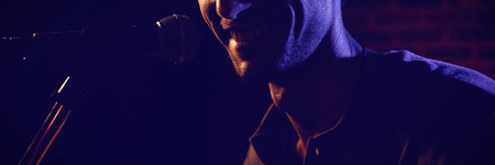 Close up of smiling male singer performing at concert in nightclubの写真素材