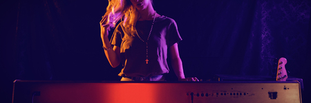 Beautiful female musician playing piano in nightclubの写真素材