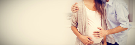 Man kissing his pregnant wife and touching his bellyの写真素材