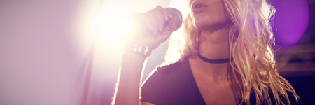 Young female singer performing at concert in nightclubの写真素材