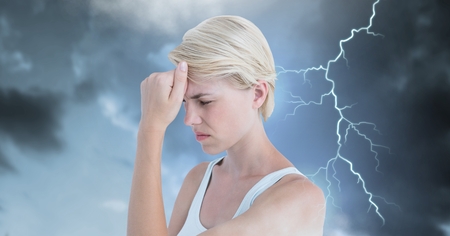 Digital composite of Lightning strikes and stressed woman with headache holding head