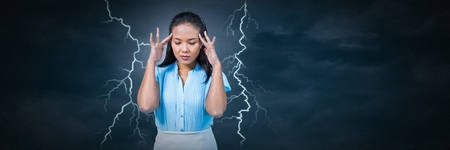 Digital composite of Lightning strikes and stressed woman with headache holding head