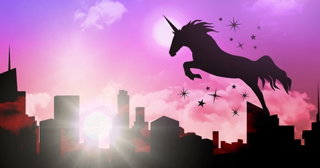 Digital composite of Unicorn silhouette jumping over cityの写真素材
