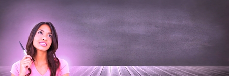 Digital composite of Woman thinking in front of wall with pink glowの写真素材