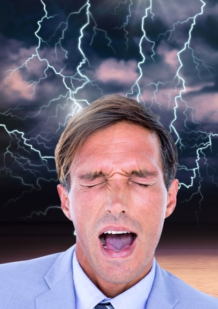 Digital composite of Lightning strikes and stressed man with headache holding headの写真素材