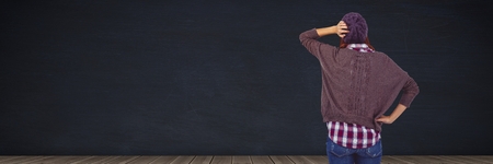 Digital composite of Woman thinking in front of blackboardの写真素材