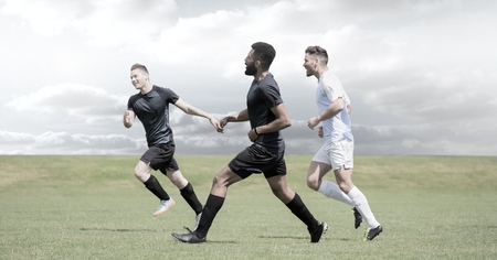 Digital composite of Soccer players on grass with sky