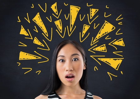Digital composite of Shocked woman with tense triangle doodles on blackboardの写真素材