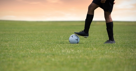 Digital composite of Soccer player on grass with footballの写真素材