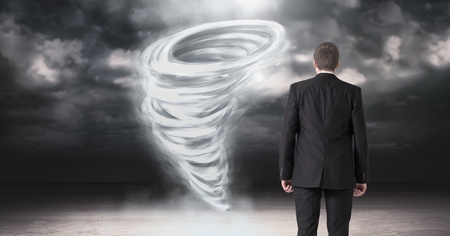 Digital composite of Tornado twister painted and dark sky with businessman lookingの写真素材