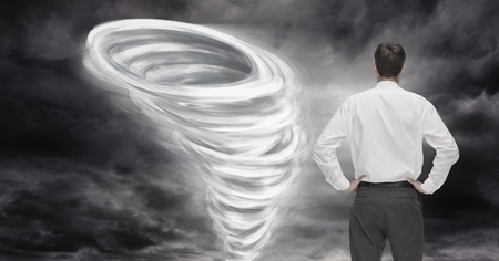 Digital composite of Tornado twister painted and dark sky with businessman lookingの写真素材