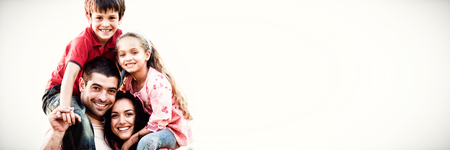 Parents giving children piggyback rides outdoorsの写真素材