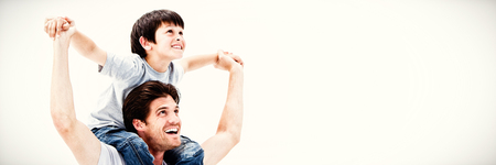 Joyful father giving piggyback ride to his son against a white background の写真素材