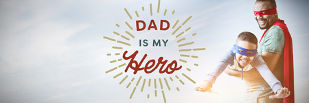 Father and son pretending to be superhero against close up of dad is my hero textの写真素材