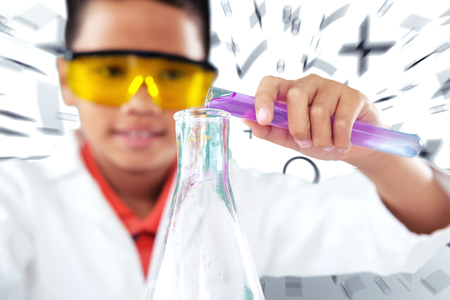 Schoolboy performing experiment against maths doodleの写真素材