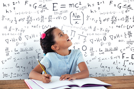 Girl looking up while writing in book against mathsの写真素材