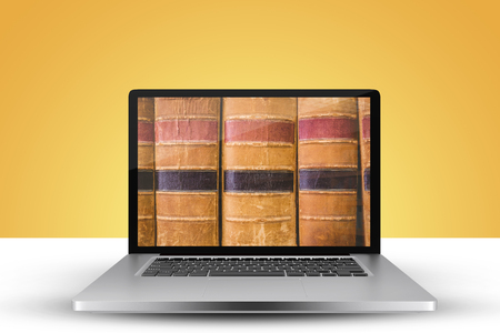 Laptop with with screen against close up of old booksの写真素材