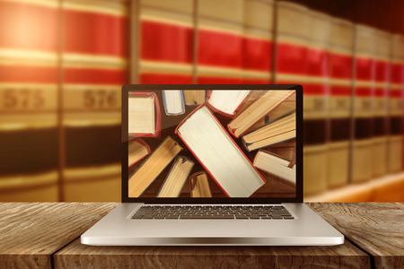 Laptop with with screen against close up of big booksの写真素材