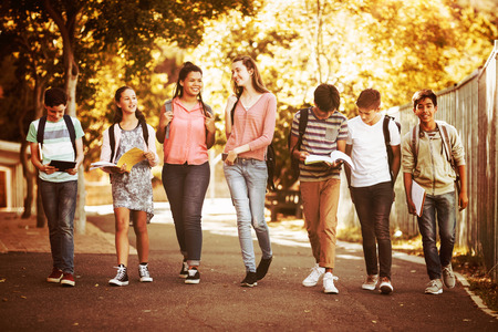 Smiling school kids walking on road in campus at schoolの写真素材