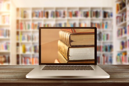 Laptop with with screen against teacher reading books to her studentsの写真素材