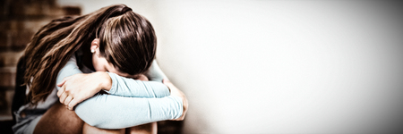 Sad schoolgirl sitting alone on staircase in school