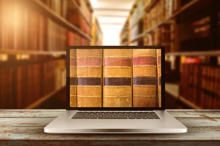 Laptop with with screen against close up of a bookshelfの写真素材