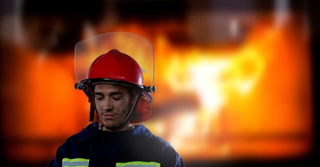Digital composite of Firefighter in front of burning fire