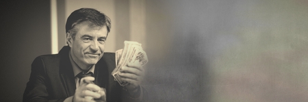 Digital composite of Wealthy man holding money notes and cigarの写真素材