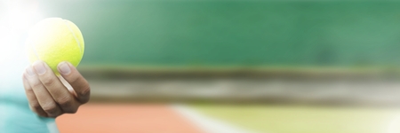 Digital composite of hand holding tennis ball in courtの写真素材