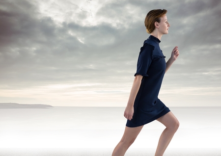 Digital composite of Businesswoman running by seaの写真素材