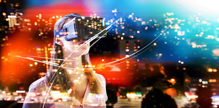 Woman using an vr against defocused image of cityscape at night