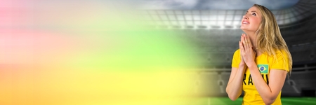 Digital composite of Brazilian soccer fan praying and hoping in stadium for win with transitionの写真素材