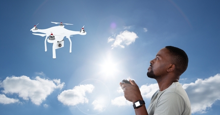 Digital composite of Man flying a drone in blue sky