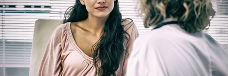 Female patient listening to doctor with concentrationの写真素材