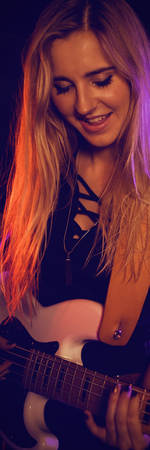 Female musicians performing in illuminated nightclubの写真素材