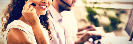 Confident female call center agent working at officeの写真素材