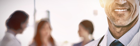 Portrait of cheerful doctor standing with stethoscope at hospitalの写真素材