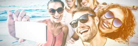 Smiling happy friends taking selfie at beach
