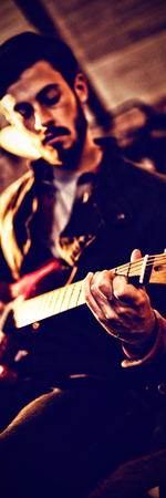 Young man playing guitar in pubの写真素材