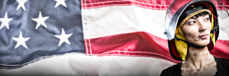 Female architect wearing helmet against white background against full frame of wrinkled american flagの写真素材