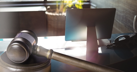 Digital composite of Gavel and computer screen on desk