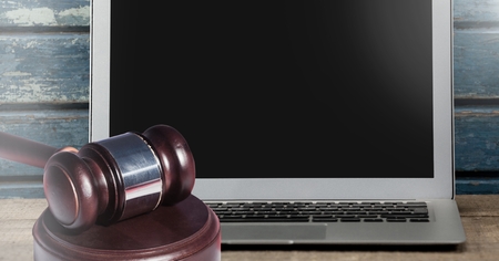Digital composite of Gavel and laptop on desk
