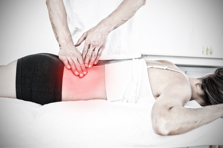 Highlighted pain against male physiotherapist massaging womans back