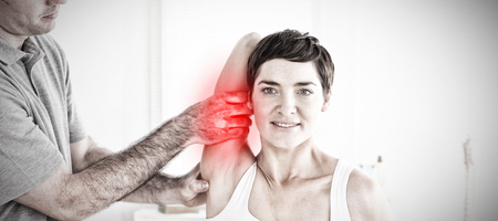 Highlighted pain against physical therapist helping patient to stretchの写真素材
