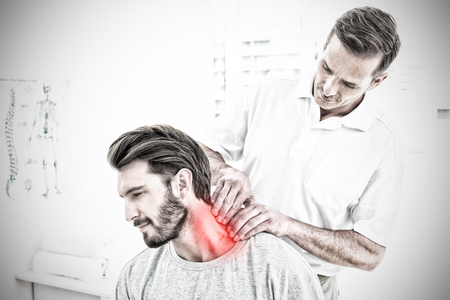 Highlighted pain against male chiropractor examining neck adjustmentの写真素材